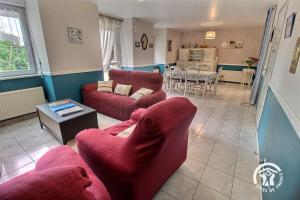 a living room with two red chairs and a table at Les cerisiers in Hinlé