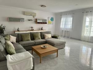 a living room with a couch and a coffee table at Villa Vistamar - Piscina privada, vistas al mar y a 5 min de la playa in Cala en Porter