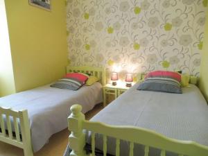 two twin beds in a room with yellow walls at Les cerisiers in Hinlé