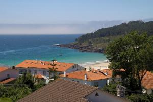 uma vista para uma praia com casas e o oceano em APARTAMENTOS DE CANELAS SUITES con AMPLIAS TERRAZAS em Portonovo
