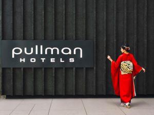 a woman in a red dress walking in front of a hotel at Pullman Tokyo Tamachi in Tokyo +230 photos