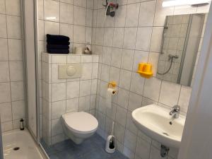 a white bathroom with a toilet and a sink at Altes Gutshaus Schwiessel in Prebberede