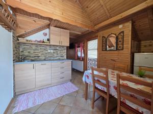 a kitchen with a table and chairs in a cabin at Apartments & Chalet Jurček in Luče