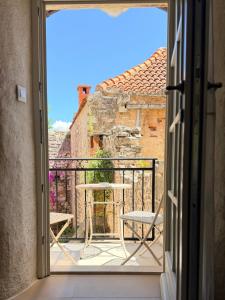 a door open to a balcony with a table and chairs at Sailor's apartment in Supetar
