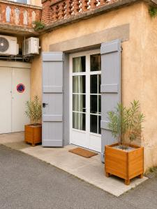 a building with a door and two potted plants outside at " Studio Vasconia " Hyper Centre - Mezzanine -Wifi in Muret
