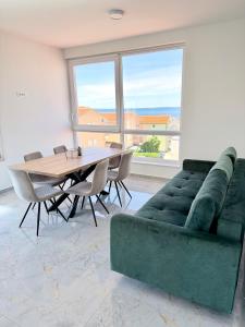 a living room with a green couch and a table at Vip Villa Tina in Novalja