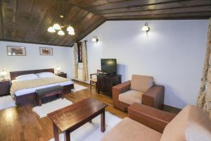 a living room with a bed a couch and a tv at Hotel Ivanov Konak i Depadans Palac in Cetinje