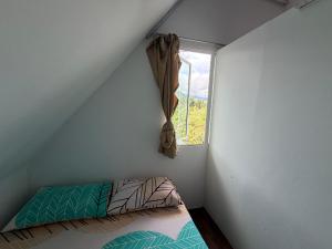 a small bedroom with a bed and a window at Amazing Grace Lodge in Kampong Kundassan