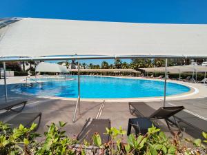 a large swimming pool with chairs and umbrellas at Palladium Villa in Side