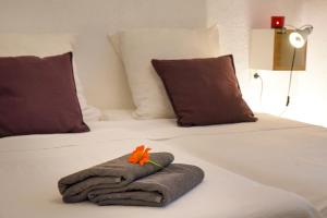 a bed with a towel and a flower on it at Charming Stone House with Green Courtyard in Stari Grad