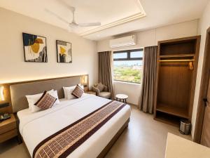 a hotel room with a bed and a window at Avsar Resort in Verāval +23 photos