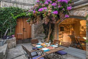 a table with a plate of food and flowers on it at Charming Stone House with Green Courtyard in Stari Grad