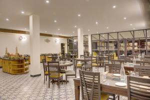 a restaurant with wooden tables and chairs and a cafeteria at Cygnett Collection in Jim Corbett