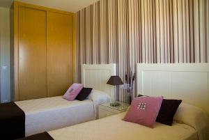 Łóżko lub łóżka w pokoju w obiekcie APARTAMENTOS DE CANELAS SUITES con AMPLIAS TERRAZAS