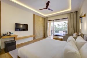 a hotel room with a bed and a tv at Cygnett Collection in Jim Corbett