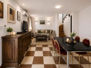 a living room with a television and a table and chairs at Quiet Oasis in the Heart of Old Town- two kitchen,3bath in Split