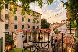 a patio with a table and chairs on a balcony at Quiet Oasis in the Heart of Old Town- two kitchen,3bath in Split