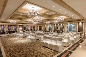 a banquet hall with white chairs and chandeliers at Tuli Imperial in Nagpur +103 photos
