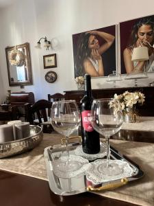 a table with two glasses and a bottle of wine at SantAntò nel cuore di Trivigno 120 mt in Trivigno