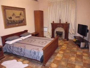 a bedroom with a bed and a fireplace and a television at Villa Klavia in Zatoka