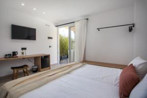 a white bedroom with a large bed and a window at Pado Living in Faliraki