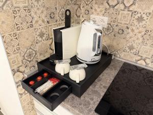 eine Kaffeemaschine auf einem schwarzen Regal in einer Küche in der Unterkunft Noir Hotel in Szeged