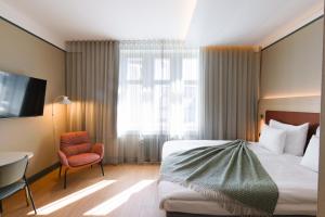 a hotel room with a bed and a chair at Original Sokos Hotel Puijonsarvi in Kuopio +58 photos