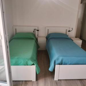 two beds sitting next to each other in a room at New semi-detached two-room apartment in Monserrato