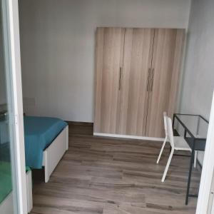 a bedroom with a desk and a bed and a table at New semi-detached two-room apartment in Monserrato