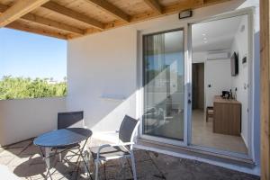 a patio with a table and chairs and a sliding glass door at Pado Living in Faliraki