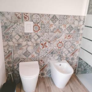 a bathroom with a toilet and a sink at New semi-detached two-room apartment in Monserrato +1 photo