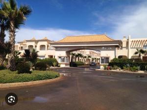 a parking lot in front of a large building at Mozona beach 2 in Sidi Rahal