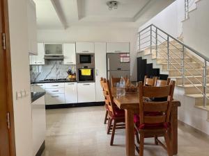 a kitchen with a table and chairs and a staircase at Mozona beach 2 in Sidi Rahal