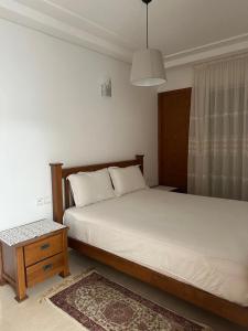 a bedroom with a bed and a table and a window at Mozona beach 2 in Sidi Rahal