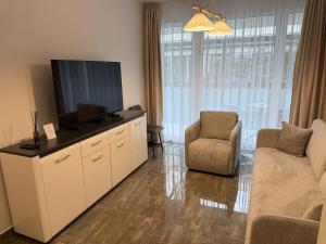 ein Wohnzimmer mit Flachbildfernseher und Sofa in der Unterkunft Noir Hotel in Szeged