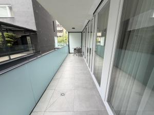 ein leerer Flur eines Gebäudes mit Glasfenstern in der Unterkunft Noir Hotel in Szeged