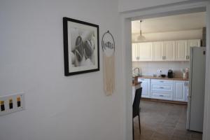 a kitchen with white cabinets and a picture on the wall at Lakuša Retreat in Latin +42 photos