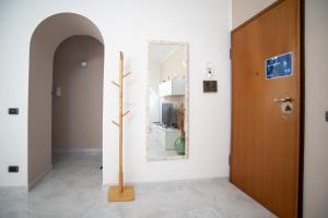 a hallway with a mirror and a wooden door at A casa di Chiara in Lecce