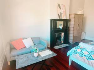 a living room with a couch and a fireplace at Perth property - Heritage Charm Meets Modern Ease close to all amenities including Midland Hospital in Midland Junction +16 photos