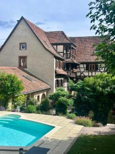 a large house with a swimming pool in front of it at L'Héritage 1779 in Duntzenheim