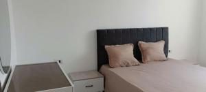 a bedroom with a bed with two pillows and a mirror at Apartement Rimsou in Kelibia