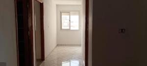 an open door to a hallway with a window at Apartement Rimsou in Kelibia