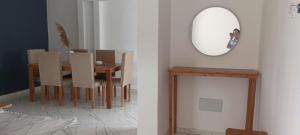 a dining room with a table and a mirror at Apartement Rimsou in Kelibia