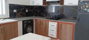 a kitchen with a stove and a washer and dryer at Apartement Rimsou in Kelibia