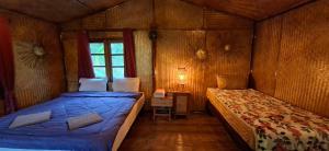 a small bedroom with two beds and a window at Tee Bungalow in the jungle in Ao Nang 