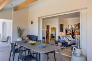 a living room with a table and a couch at Villa Bollaccia - piscine privée proche de la mer in Aregno