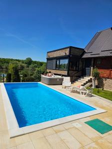 a swimming pool in front of a house at Vikendice Božić in Višnjićevo