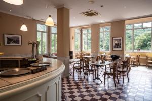 a restaurant with tables and chairs and windows at Gran Hotel Pelayo in Covadonga