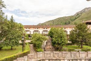 a building with a fountain in the middle of a park at Gran Hotel Pelayo in Covadonga