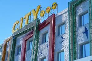 a building with a neon sign on top of it at City Hostel Shymkent in Shymkent